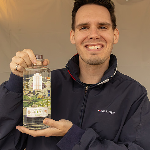 Vendor smiling with bottle of Missouri Botanical Garden gin